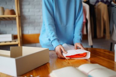 Masaya bir paket hazırlıyorum. Nline mağazası, küçük işletme sahibi, satıcı, girişimci, paketleme çantası, posta kutusu, masada bir paket hazırlamak. E-ticarette sevkiyat dağıtımı kavramı.