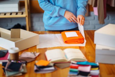 Masaya bir paket hazırlıyorum. Nline mağazası, küçük işletme sahibi, satıcı, girişimci, paketleme çantası, posta kutusu, masada bir paket hazırlamak. E-ticarette sevkiyat dağıtımı kavramı.