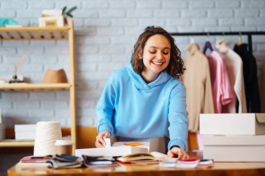 Masaya bir paket hazırlıyorum. Nline mağazası, küçük işletme sahibi, satıcı, girişimci, paketleme çantası, posta kutusu, masada bir paket hazırlamak. E-ticarette sevkiyat dağıtımı kavramı.