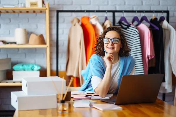 Gülümseyen kadın dizüstü bilgisayardan emir alır. Teslimat sahibi çalışıyor, müşteriye göndermeden önce doğrulama siparişini kontrol ediyor. Çevrimiçi satış.