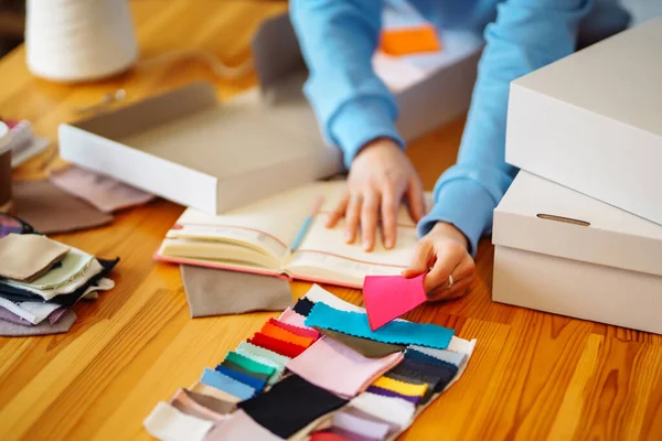 Çok renkli kumaş örneklerinin kataloğu. Çeşitli renkli örneklerden döşeme kumaşı rengi ve dokusu seçiliyor. 