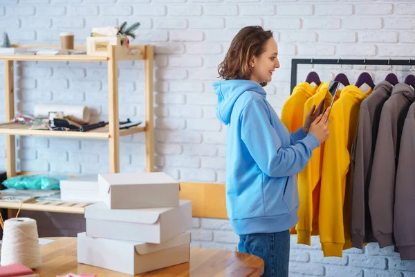 Küçük işletme sahibi, girişimci, ecommerce giyim mağazasının siparişlerini kontrol eden tablet satıcı. Çevrimiçi satış.