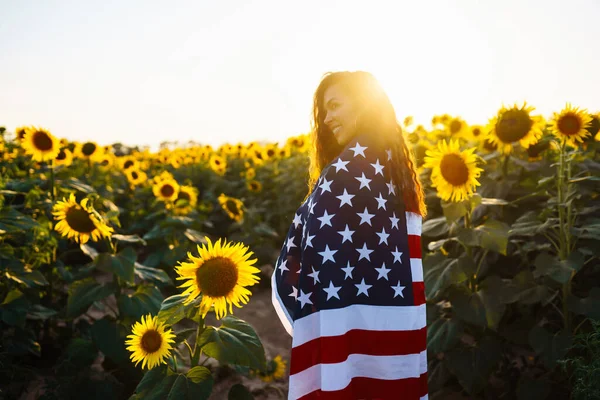 Ung Kvinna Håller Stolt Den Amerikanska Flaggan Solrosfältet Patriot Hissar — Stockfoto