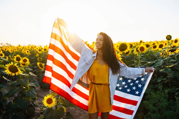 Ung Kvinna Håller Stolt Den Amerikanska Flaggan Solrosfältet Patriot Hissar — Stockfoto