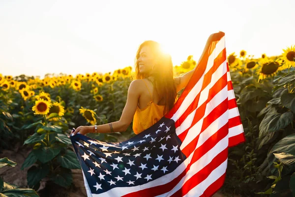 Eine Junge Frau Hält Stolz Eine Schwenkende Amerikanische Flagge Sonnenblumenfeld — Stockfoto