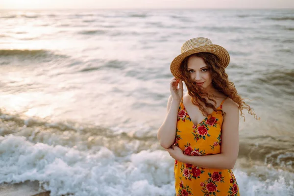 Beautiful woman in summer dress and hat walking on the beach. Travel, weekend, relax and lifestyle concept.