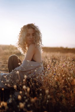 Doğada dinlenen genç bir kadın. İnsanlar, yaşam tarzı, rahatlama ve tatil konsepti. Moda, tarz kavramı.