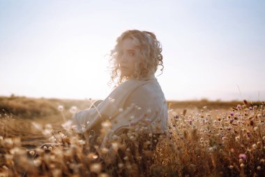 Doğada dinlenen genç bir kadın. İnsanlar, yaşam tarzı, rahatlama ve tatil konsepti. Moda, tarz kavramı.