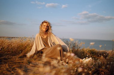 Doğada dinlenen genç bir kadın. İnsanlar, yaşam tarzı, rahatlama ve tatil konsepti. Moda, tarz kavramı.