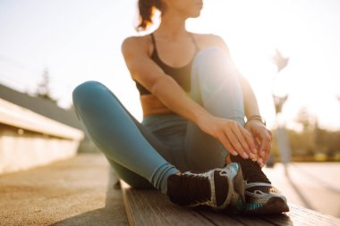 Spor kıyafetli genç bir kadın sabahları dışarıda egzersiz yapıyor. Spor kadını esneme egzersizi yapıyor. Spor, aktif yaşam, spor eğitimi, sağlıklı yaşam tarzı..