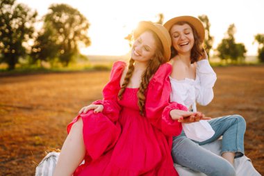 Samanlığın yanında eğlenen iki genç kadın. Moda konsepti. Doğa, tatil, rahatlama ve yaşam tarzı. Güzel rakamlar. Süper ruh hali. Yaz konsepti.