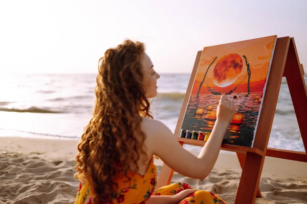 Young female artist drawing the picture at the beach. Hobby and leisure concept. Talent and creativity. Canvas Painting.