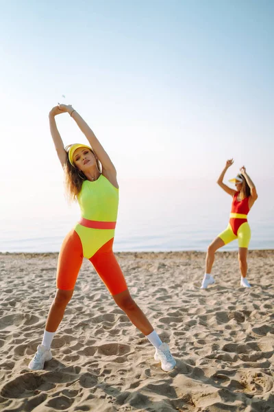 穿着泳衣的年轻妇女正在海滩上接受训练 美丽的女人在海滩上跳舞 有氧运动和人的概念 积极运动 — 图库照片