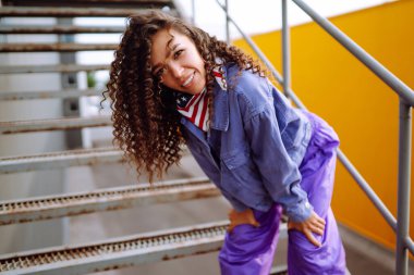 Şık giyinmiş, dans eden ve birkaç hareket gösteren bir sokak dansçısı. Spor, dans ve şehir kültürü konsepti.