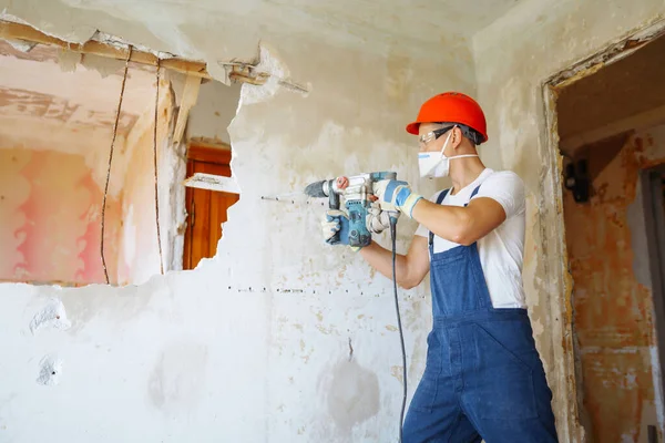 Repairer in hardhat  and boiler suit with tools. Apartment repair and renovation concept. Building, working equipment and people concept