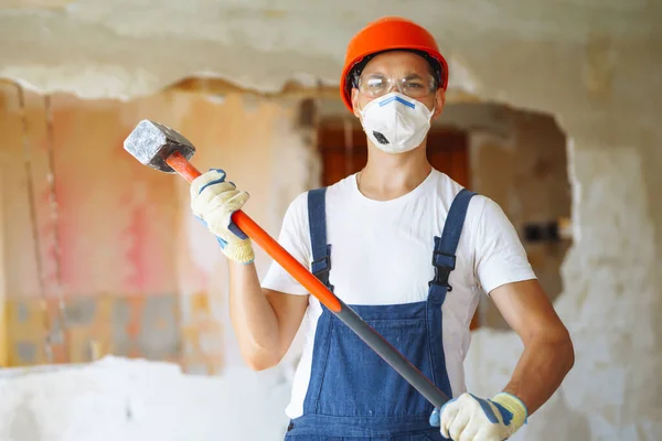 Repairer in hardhat  and boiler suit with tools. Apartment repair and renovation concept. Building, working equipment and people concept