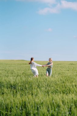 Yeşil tarlada iki moda kadını. Özgürlük yolculuğu. Yaz manzarası.