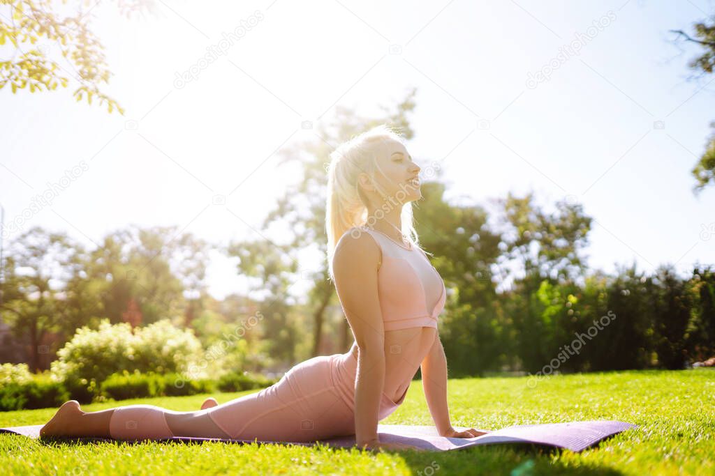 Young woman doing excercise at the public park. Fitness woman doing yoga exercises in the morning. Sport, Active life.