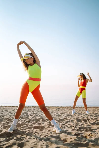 身穿泳衣的漂亮女人在海滩上跳舞 三个女人早上在训练 有氧运动和人的概念 积极运动 — 图库照片