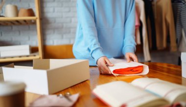 Masada bir paket hazırlamak için yakın plan. Çevrimiçi küçük işletme girişimcileri mağazada çalışıyor müşterilere dağıtmak için ürünler hazırlıyorlar. İndirme teslimat kavramı.