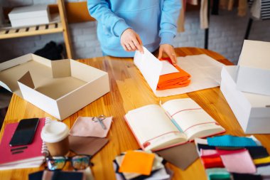Masada bir paket hazırlamak için yakın plan. Çevrimiçi küçük işletme girişimcileri mağazada çalışıyor müşterilere dağıtmak için ürünler hazırlıyorlar. İndirme teslimat kavramı.