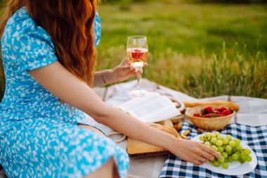 Yaz pikniği. Doğada dinlenen genç bir kadın. İnsanlar, yaşam tarzı, rahatlama ve tatil kavramı.