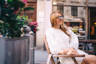 Genç kadın rahat bir kafede takılıyor, etrafa bakıyor, mutlu duygular içinde. Gezgin kadın..