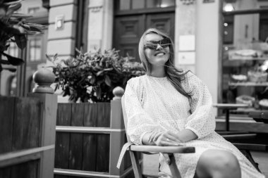 Genç kadın rahat bir kafede takılıyor, etrafa bakıyor, mutlu duygular içinde. Gezgin kadın..