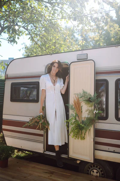 Karavanın yanında güzel, şık bir gelin. Kamp sezonu. Evlilikten. Mutlu yeni evli kadın.