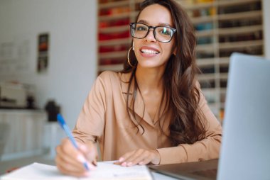 Çevrimiçi konferans, eğitim. Dizüstü bilgisayarla çalışan genç kız, üniversite kütüphanesinde öğreniyor. Serbest Çalışan, İş, Eğitim Konsepti.