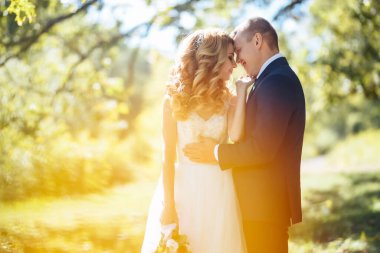 Happy wedding couple enjoy each other in the park. Wedding day. Marriage. The concept of youth, love, fashion and lifestyle.