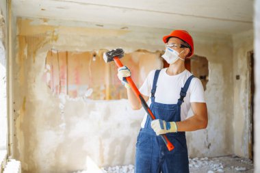 Repairer in boilersuit holding tools. Apartment repair and renovation concept. Building, working equipment and people concept.
