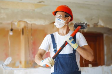 Repairer in boilersuit holding tools. Apartment repair and renovation concept. Building, working equipment and people concept.