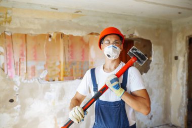 Repairer in boilersuit holding tools. Apartment repair and renovation concept. Building, working equipment and people concept.