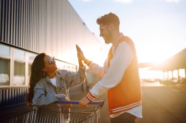 Selfie time. Young friends holding mobile phone taking selfie photo using smartphone camera. Shopping time. Blogging. Shopaholic, customer, sale concept.