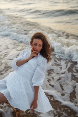 Beautiful woman walking along the seashore. People, freedom, lifestyle, travel and vacations concept.
