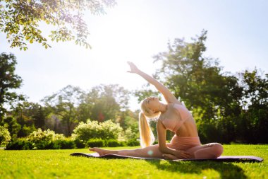 Young woman doing yoga excercise at the public park.  Sport, Active life. Calmness and balance, a healthy lifestyle.