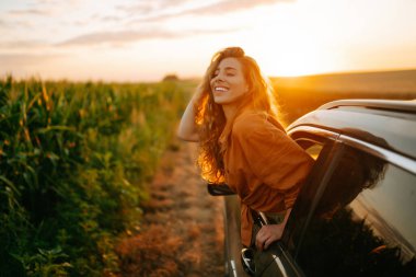 Towards adventure! Young woman is resting and enjoying the trip in the car.  Lifestyle, travel, tourism, nature, active life.