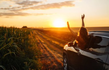Towards adventure! Young woman is resting and enjoying the trip in the car.  Lifestyle, travel, tourism, nature, active life.