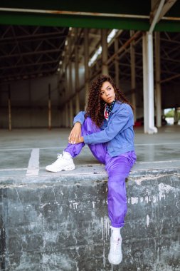 Funky young woman dancing alone in the street. Sport, dancing and urban culture concept. Fashion lifestyle.