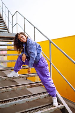 Funky young woman dancing alone in the street. Sport, dancing and urban culture concept. Fashion lifestyle.