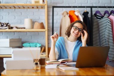 Small business owner, entrepreneur, seller with laptop analyze sales, new orders to be sent and check stocks. Online sales.