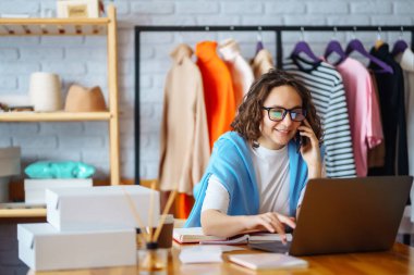 Small business owner, entrepreneur, seller with laptop analyze sales, new orders to be sent and check stocks. Online sales.