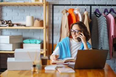 Small business owner, entrepreneur, seller with laptop analyze sales, new orders to be sent and check stocks. Online sales.