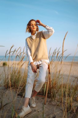 Stylish woman enjoying autumn weather outdoor. Fashion, style concept. People, lifestyle, relaxation and vacations concept.