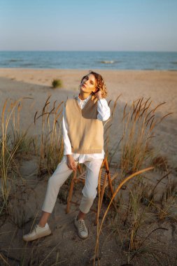 Stylish woman enjoying autumn weather outdoor. Fashion, style concept. People, lifestyle, relaxation and vacations concept.