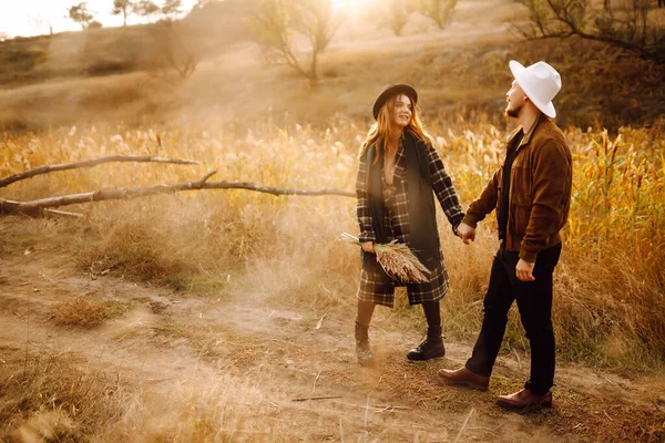 Lovely hipster couple resting in nature. People, lifestyle, relaxation and vacations concept. Autumn Fashion, style concept.