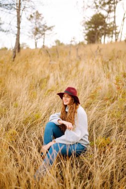 Stylish woman  in hat enjoying autumn weather in the park. Fashion, style concept.