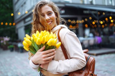 Beautiful woman with phone while walking in the street. Happy woman typing sms on smartphone in city. Lifestyle, travel, tourism, nature.