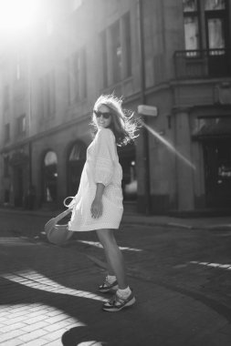 Happy woman walking around the city on a city street. People, fashion, lifestyle, travel and vacations concept.